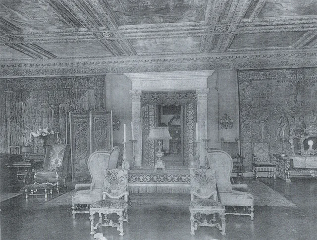 Henry Poor’s music room facing an ornamental doorway, with tapestries, upholstered chairs and a decorated ceiling.
