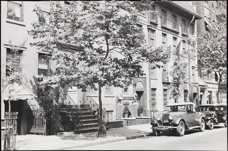 Trees, stoops, row houses and parked cars on East 19th Street in Carl Van Vechten’s 1932 photograph.