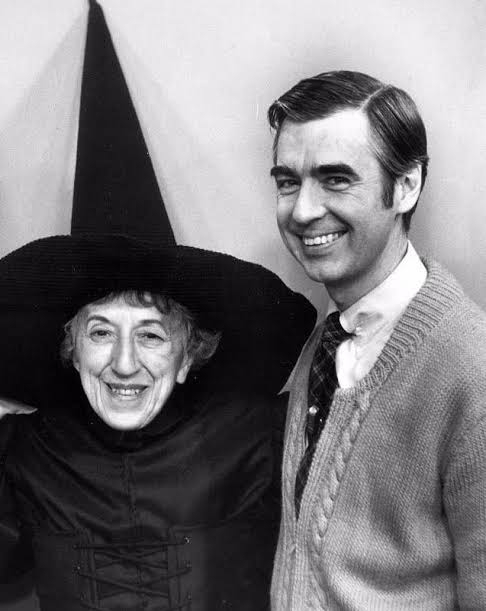 Margaret Hamilton smiling in the Wicked Witch’s hat and costume beside Fred Rogers.