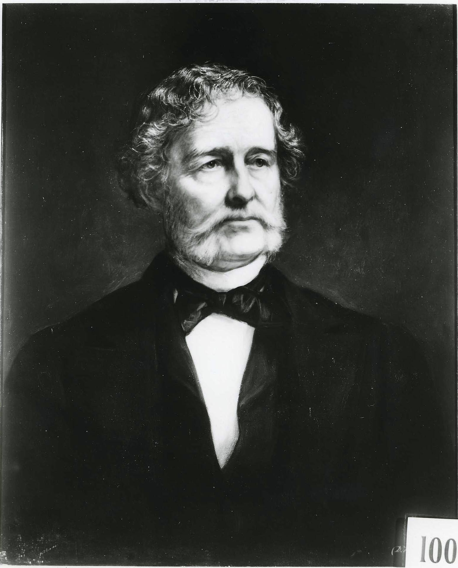 Black-and-white photograph of Daniel Huntington’s 1882 portrait of Samuel B. Ruggles, showing an older man with curled hair, side whiskers, a dark coat and black bow tie.