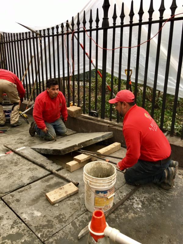 Workers repairing and leveling the bluestone sidewalk beside Gramercy Park in January 2017.