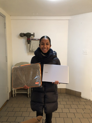 A student holds a laptop and its carrying case.