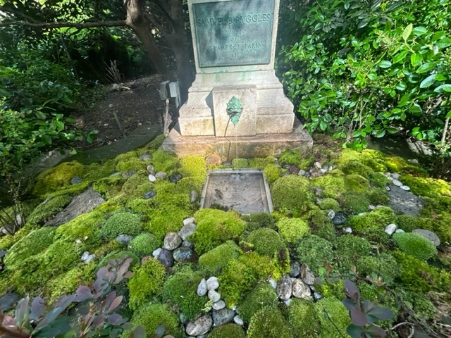 Moss and ferns planted around the base of the fountain.