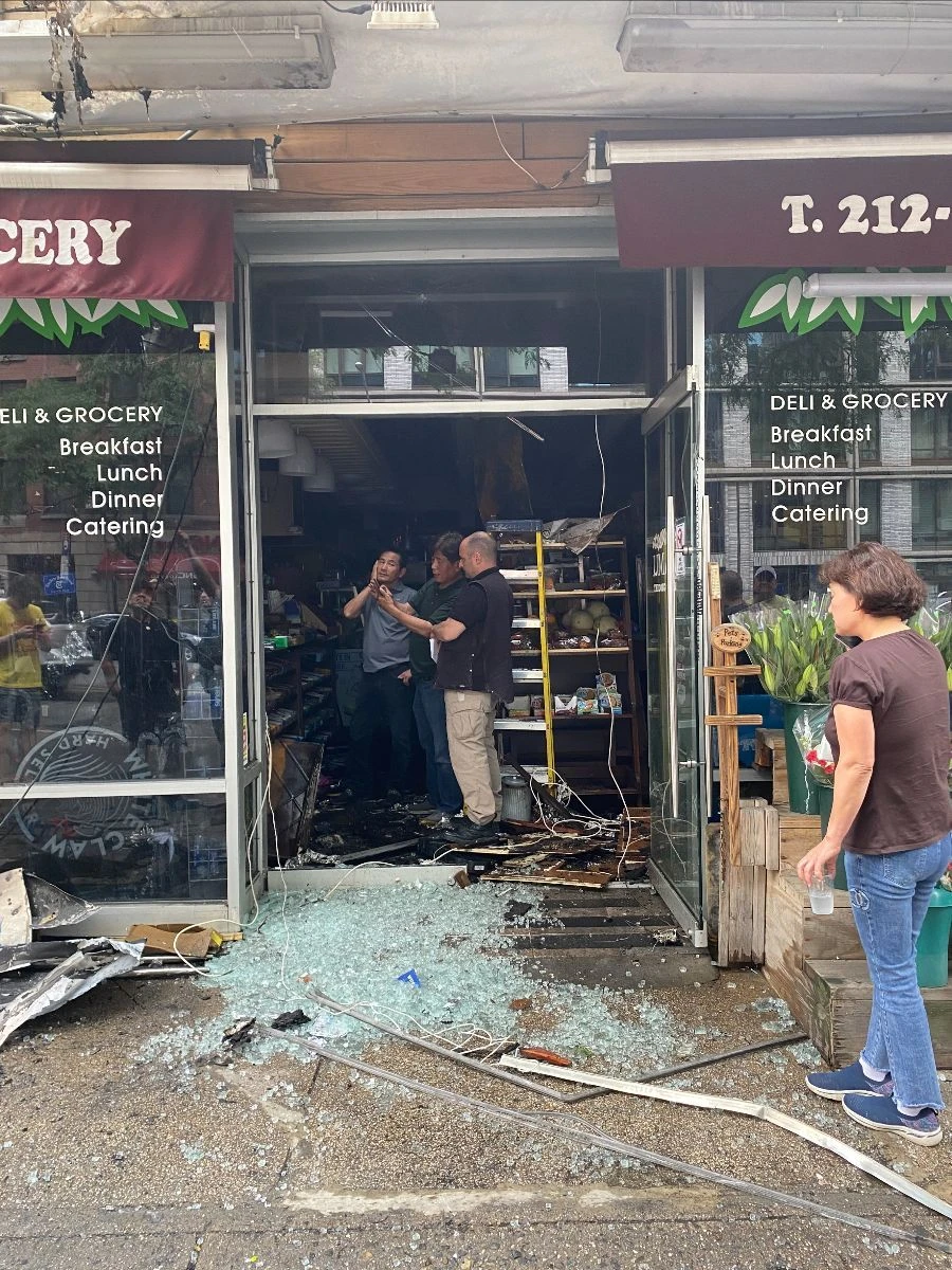 People work at the damaged entrance to Namu Deli.