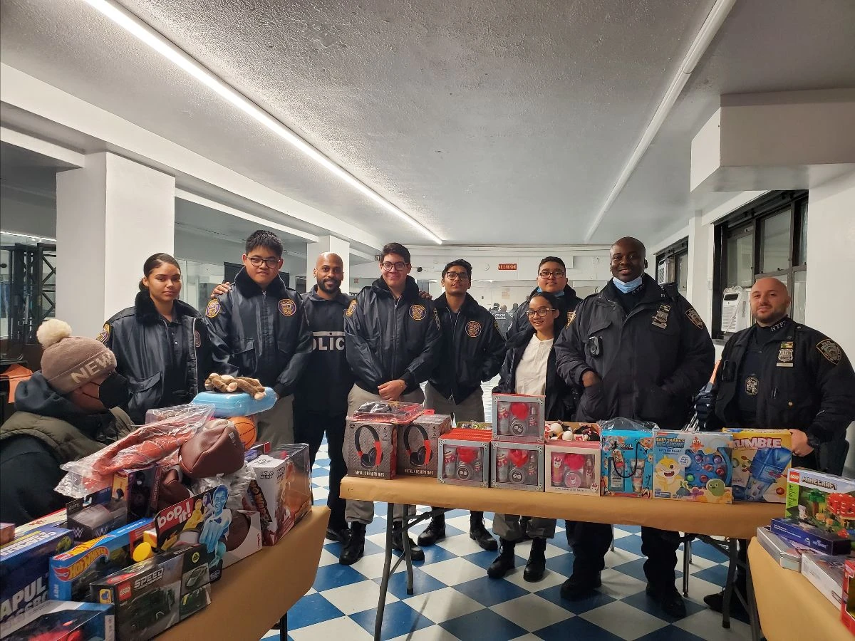 Officers and volunteers stand behind tables of donated toys.