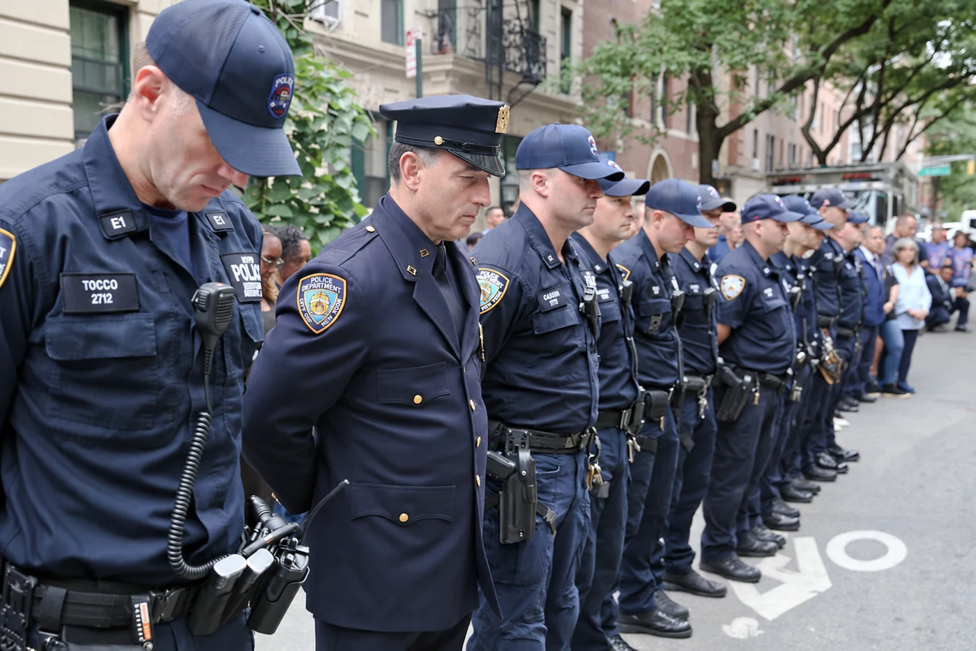 Uniformed police officers stand with heads bowed at the remembrance ceremony.